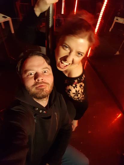 Foto aus dem Stück Lametta Lasziv. Ein Mann und eine Frau schauen nach oben in die Kamera. Er reißt die Augen weit auf. Sie ruft etwas. Rotes Licht im Hintergrund.