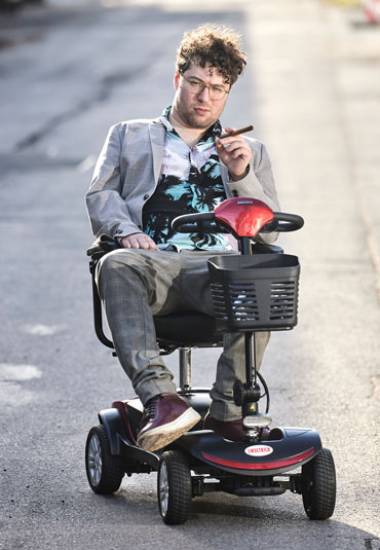 Junger Mann im Rollstuhl mit Zigarre